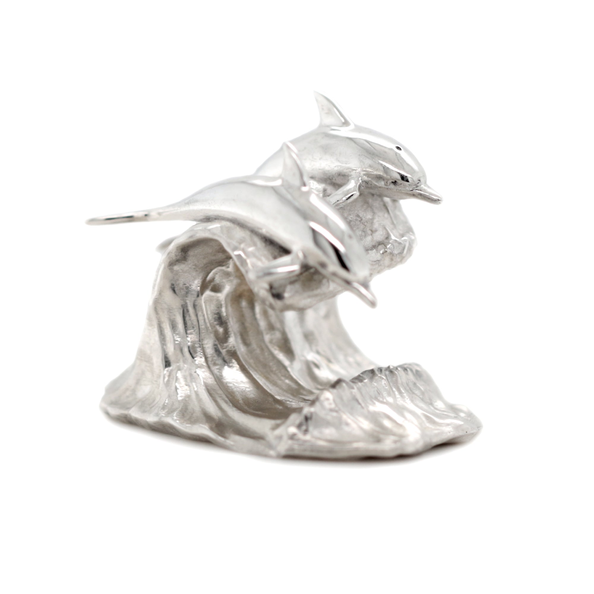 Silver sculpture of two dolphins on a wave